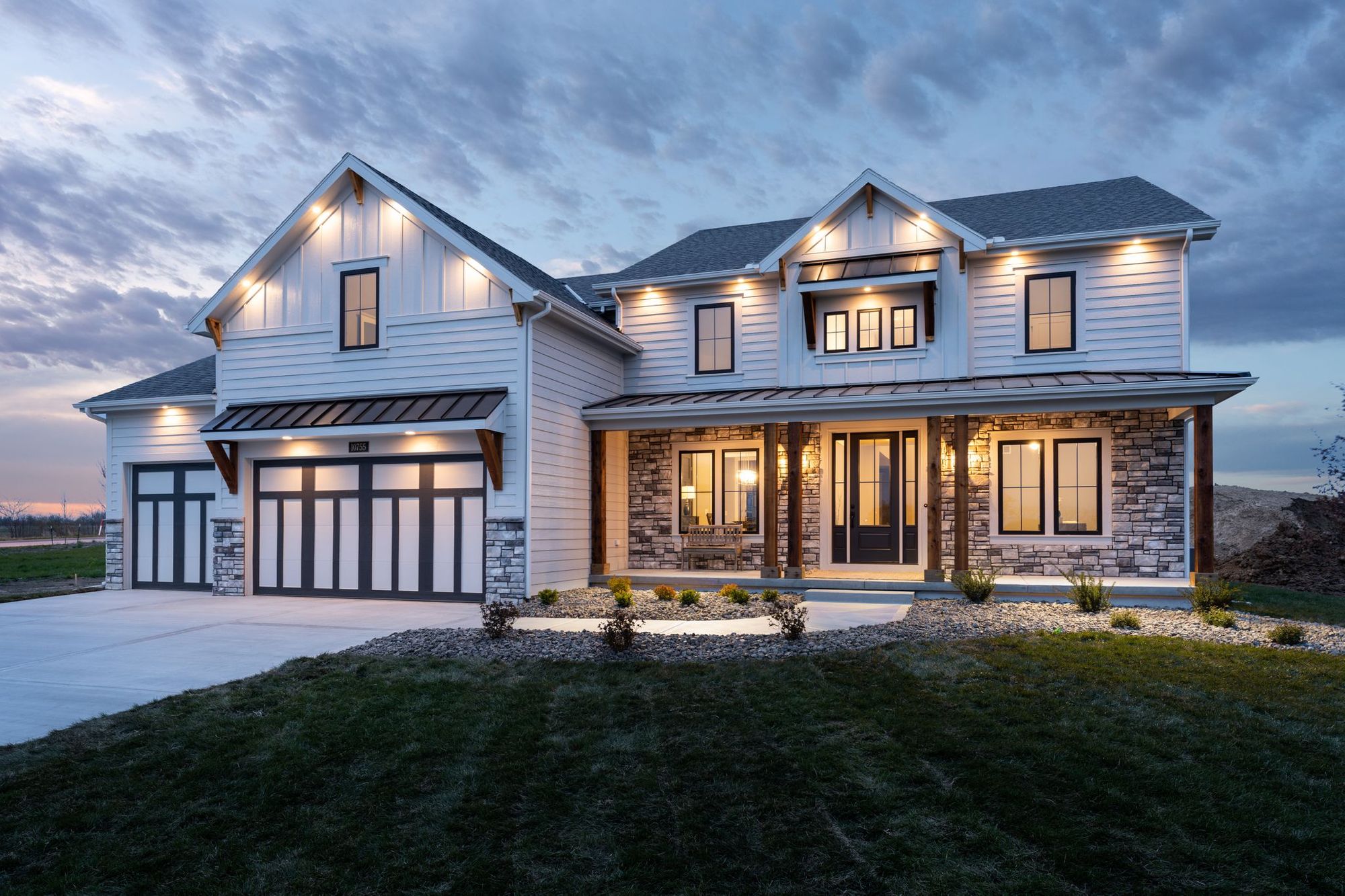 An award-winning new home is shown under a summer dusk sky at a Hunt Midwest master planned community.